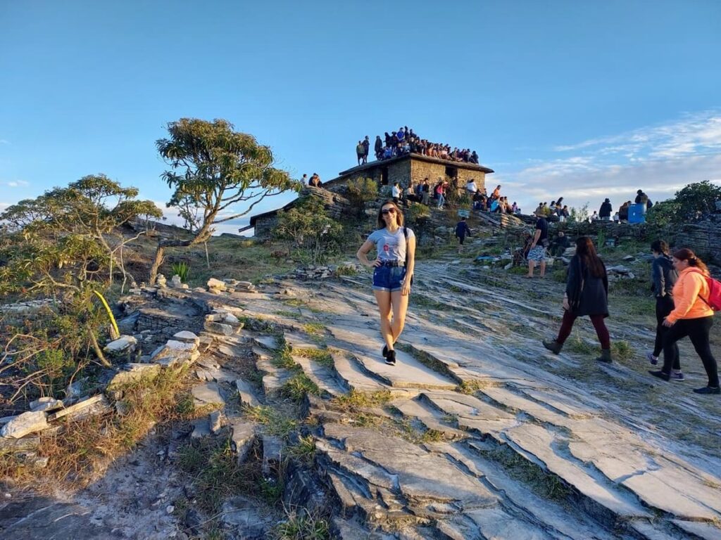 Imagem mostra turista visitando a Casa da pirâmide, enquanto curte os festivais em São Thomé das Letras.