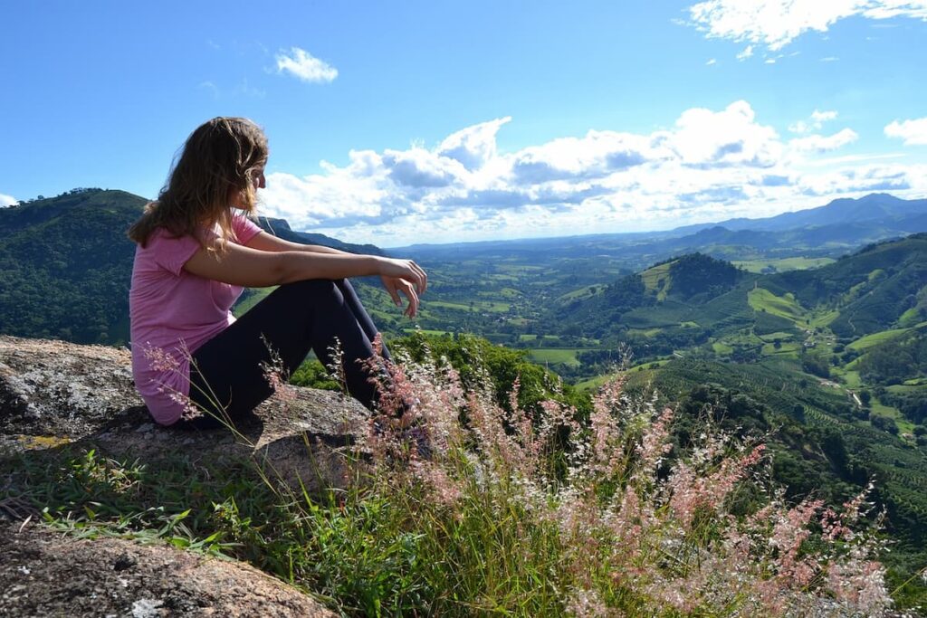 Imagem mostra turista apreciando a paisagem em um dos destinos de ecoturismo em Minas Gerais.