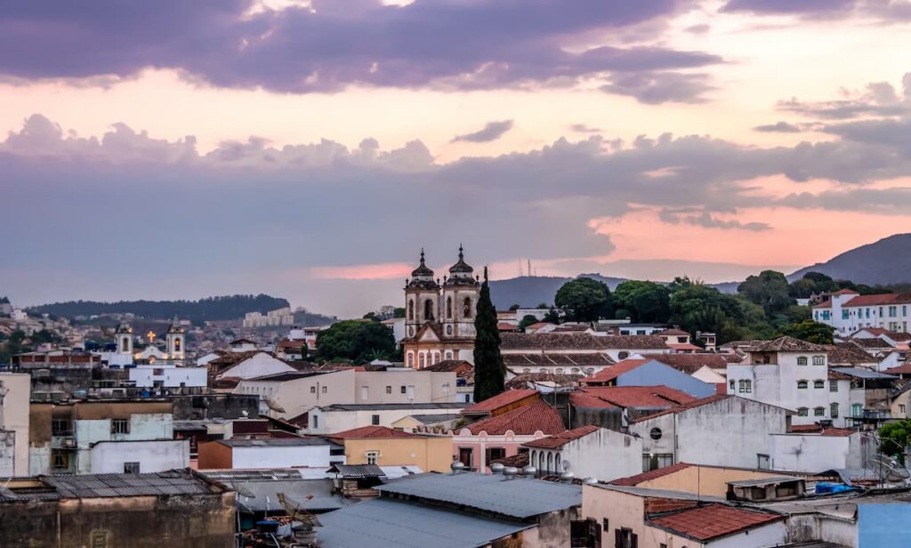 Imagem mostra cidade de São João Del Rei ao pôr do sol.