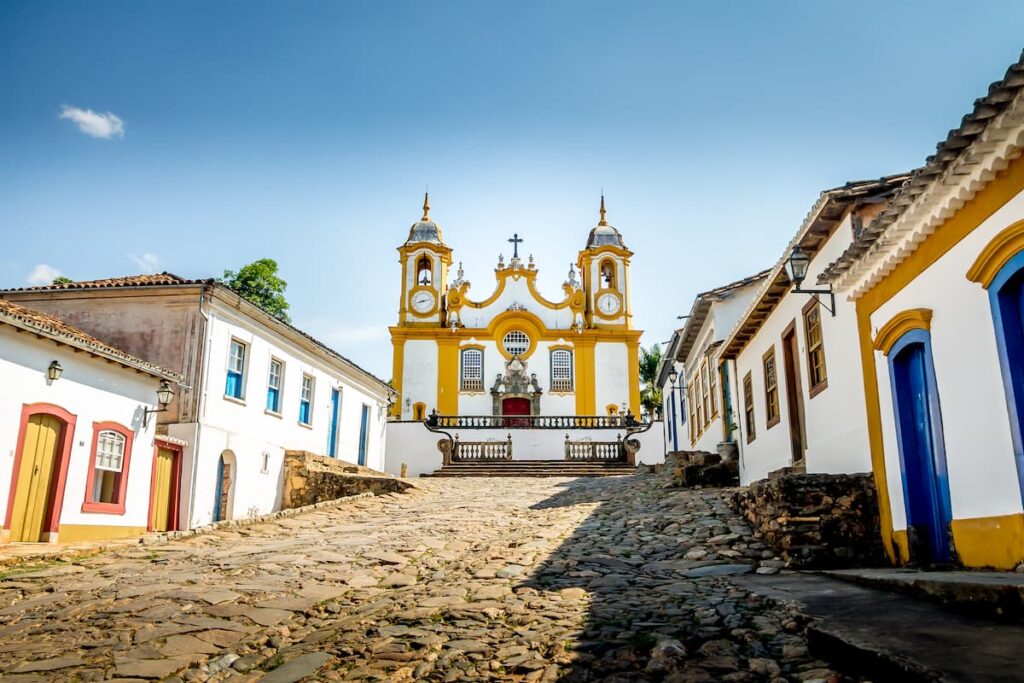 Imagem mostra casas coloniais e Igreja em Tiradentes, Minas Gerais.