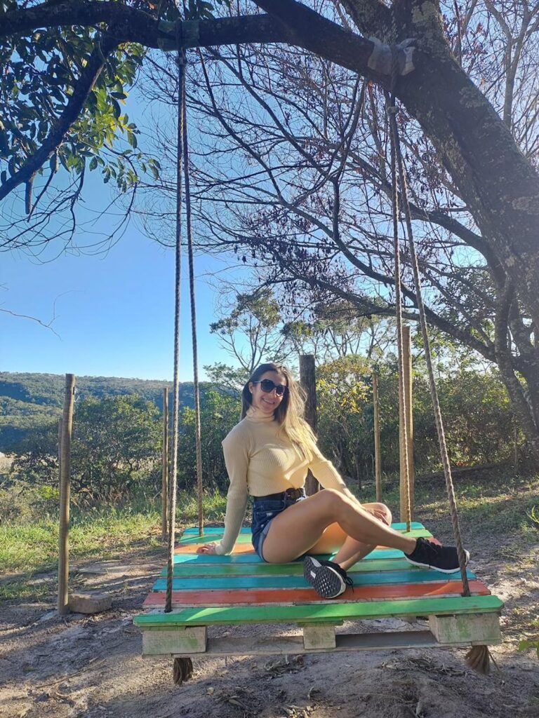Imagem mostra turista apreciando o outono em São Thomé das Letras.