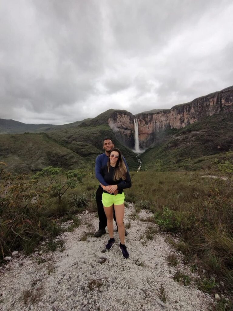 Imagem mostra casal de turistas no mirante da Cachoeira do Tabuleiro em Conceição do Mato Dentro.