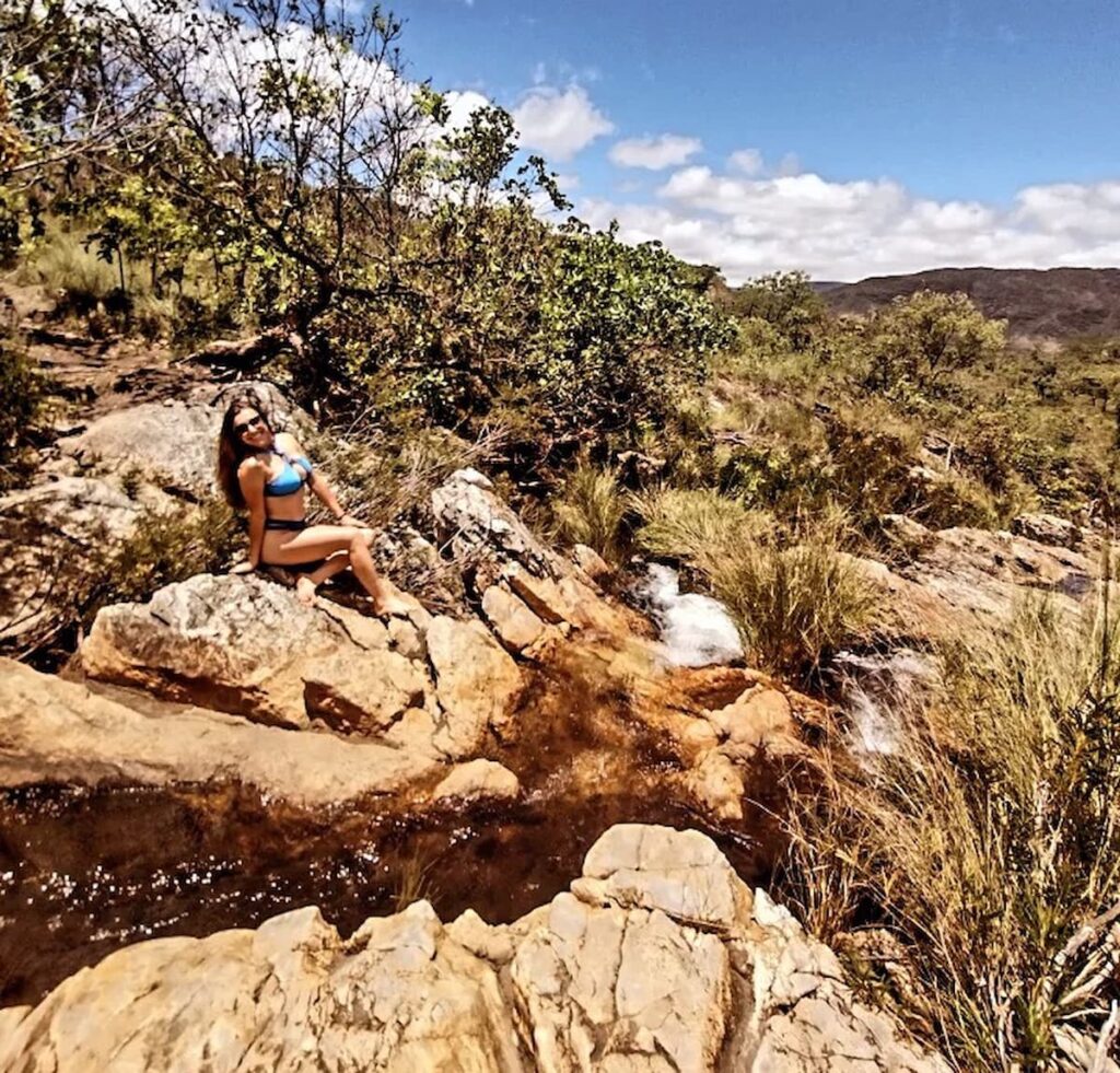 Imagem mostra turista em cachoeira no Parque Nacional da Serra do Cipó. Saber quando ir na serra do cipó é fundamental para aproveitar esse destino ao máximo.